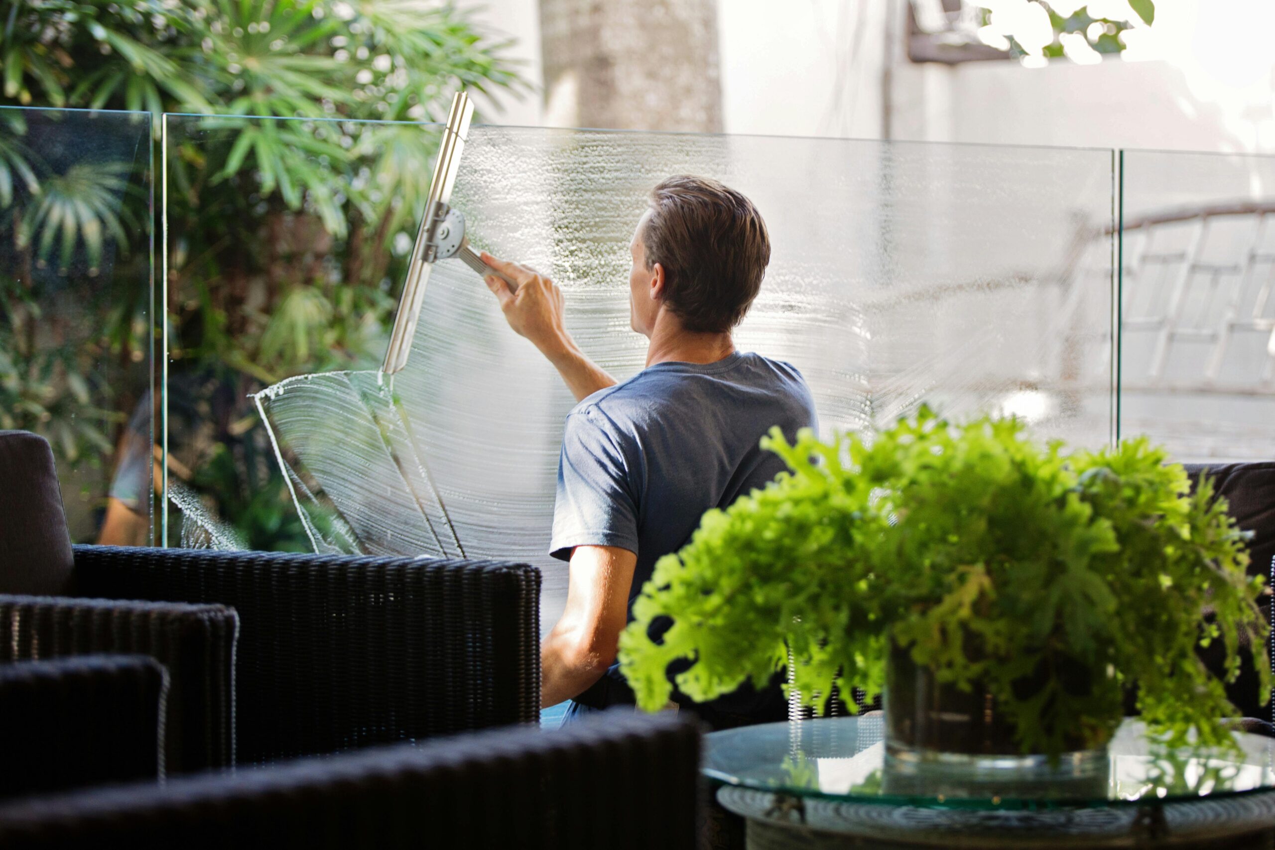 A man cleaning a glass window in a restaurant.